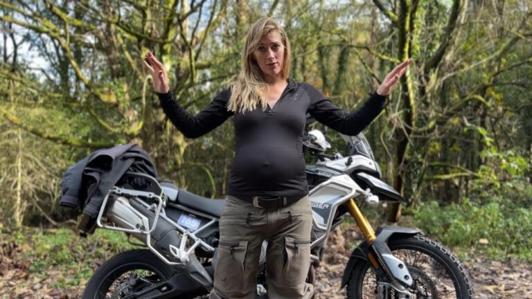 a woman standing in front of a motorcycle