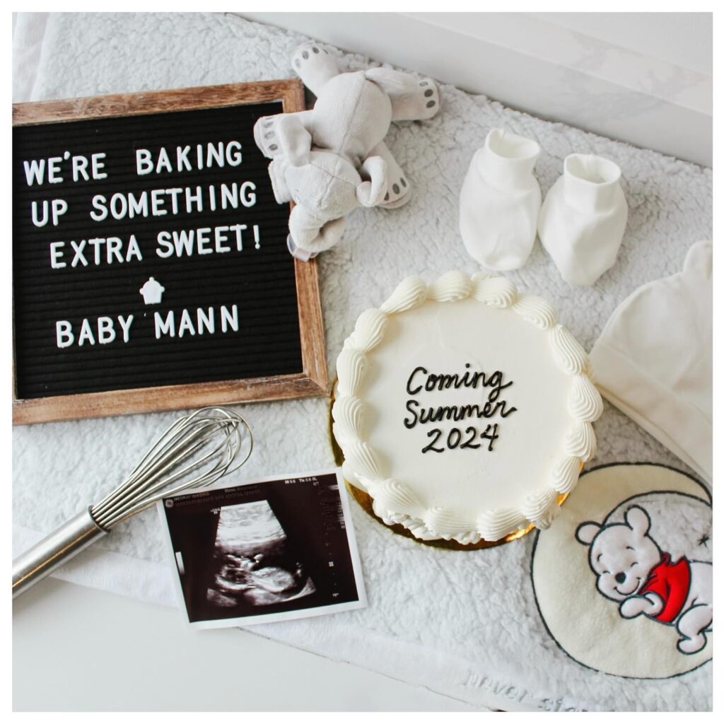 a cake with a letter board next to a baby picture