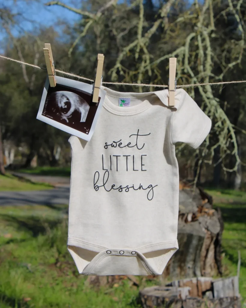 A simple and timeless way to announce your pregnancy! A neutral-toned onesie and ultrasound photo clipped to a clothesline create a natural and heartwarming reveal.