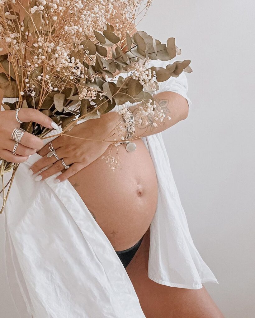 a pregnant woman holding flowers